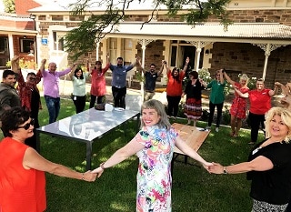 Staff from Resthaven Western Community Services hold hands in a circle to celebrate Harmony Day
