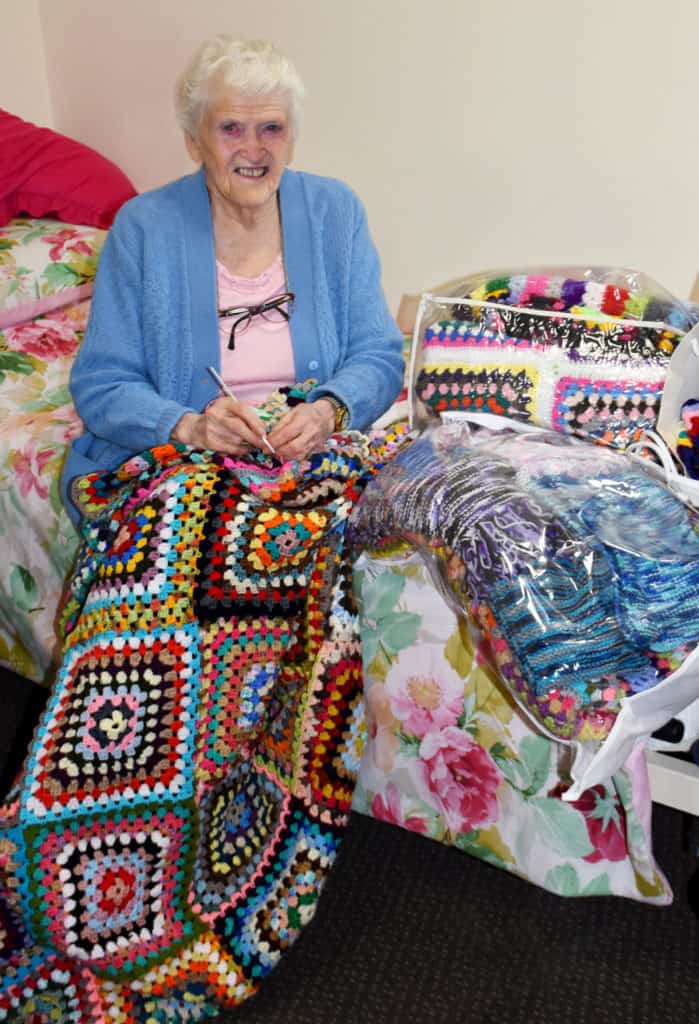Elderly lady makes colourful crochet rugs