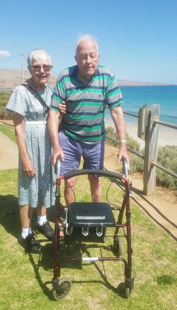 elderly couple walking by the beach