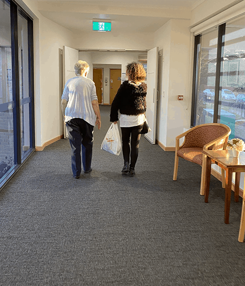 two women walking inside aged care ome