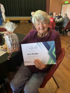 Older woman with third place certificate and gift