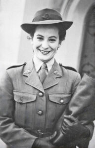 Black and white photo of a young woman smiling broadly and wearing a service uniform